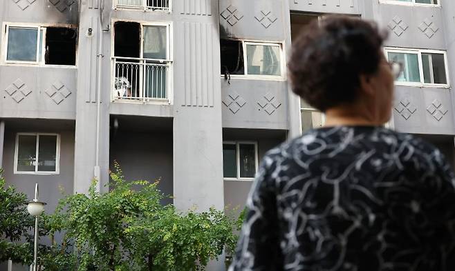 14일 전날 화재가 발생해 80대 노모와 50대 아들이 숨진 부산 북구 만덕동의 한 아파트에서 주민들이 합동 감식을 지켜보며 안타까워하고 있다. 2025.7.14 연합뉴스