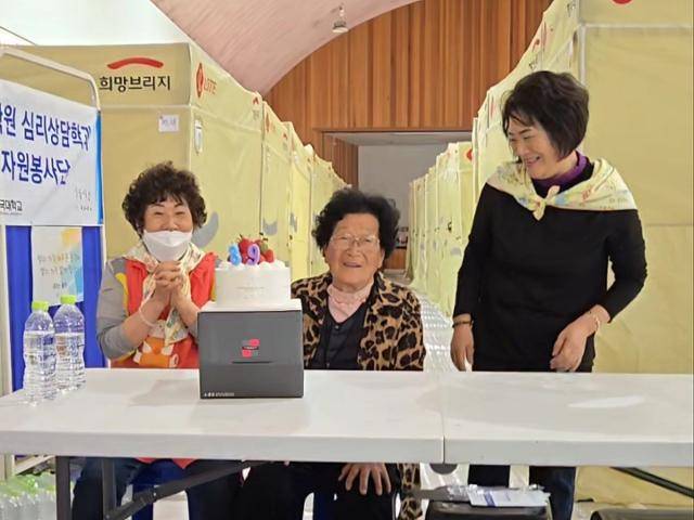 서복래(가운데) 할머니가 4월 18일 안동시 길안면 이재민 대피소 길안중 체육관에서 생일잔치를 하고 있다. 손용락씨 제공