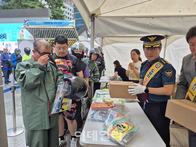 16일 오전 서울지하철 2호선 강남역 인근 광장에서 열린 5대 반칙운전 근절 캠페인에서 백현석 서울강남경찰서장이 이륜차 운전자에게 헬멧을 전달하고 있다. (사진=정윤지 기자)