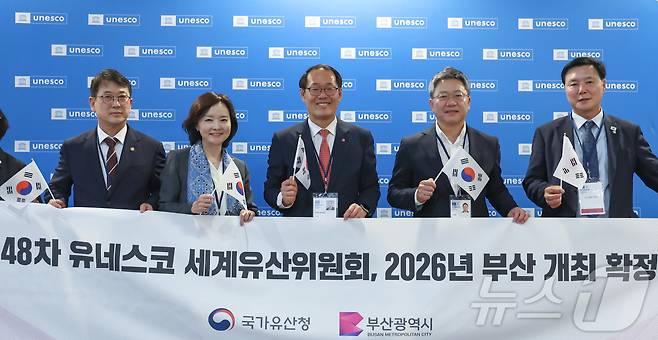 2026년 세계유산위원회 개최지로 부산이 확정된 16일 새벽(한국시간) 프랑스 파리 유네스코 본부에서 최응천 국가유산청장(왼쪽부터)과 박상미 주유네스코 대표부 대사, 이준승 부산시 행정부시장, 국민의힘 박정하 의원, 더불어민주당 조계원 의원이 플래카드를 들고 기념 촬영을 하고 있다. 2025.7.16/뉴스1 ⓒ News1 이준성 기자