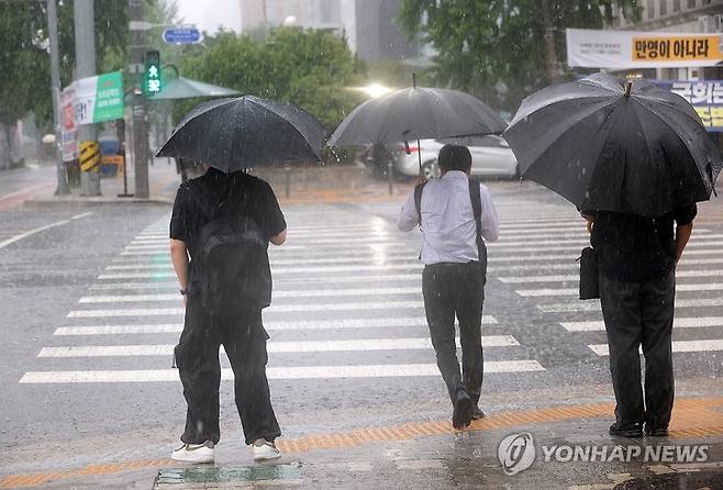 지난 8일 서울 영등포구 여의도 국회 인근에서 시민들이 우산을 쓰고 걸어가고 있다. 연합뉴스