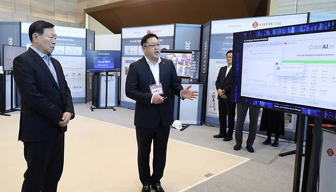 롯데그룹 신동빈 회장(왼쪽)이 지난 1월 9일 서울 롯데월드타워에서 열린 ‘2025 상반기 VCM’에 앞서 롯데케미칼의 ‘AI 기반 컬러 예측 시스템’에 대한 설명을 듣고 있다. 롯데그룹 제공