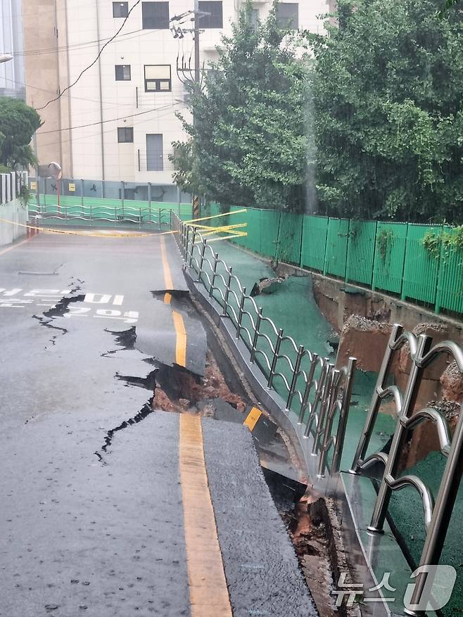 시간당 80㎜의 극한 호우가 쏟아진 17일 오후 2시 20분쯤 광주 계림동 광주고등학교 인근 인도와 도로가 갈라졌다는 신고가 접수됐다. 사진은 통제된 현장 모습. (광주 동구 제공. 재판매 및 DB 금지) 2025.7.17/뉴스1