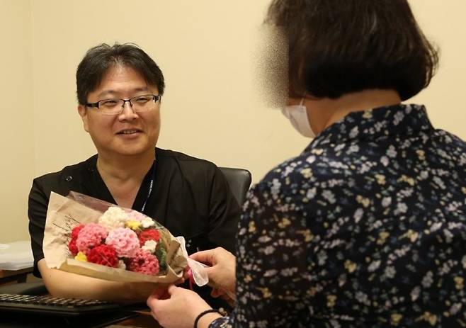 말기신부전 환자인 경 씨가 두 번째 신장이식수술로 건강을 되찾은 뒤 정병하 서울성모병원 신장내과 교수에게 뜨개질로 만든 카네이션 꽃다발을 전하고 있다. 서울성모병원 제공.