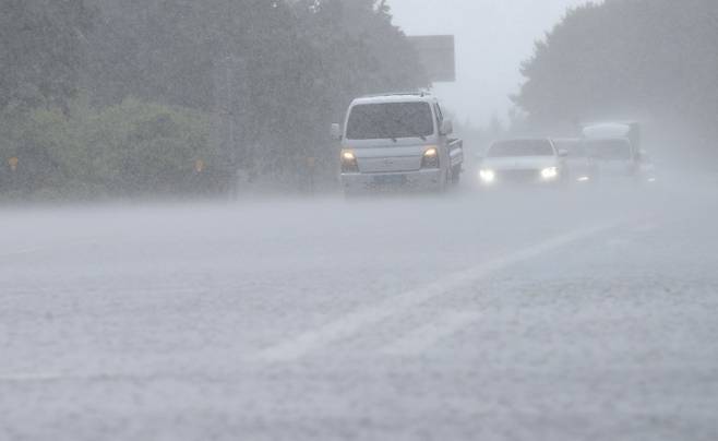비구름대가 활성화한 18일 오후 제주시 용강동 제주마 방목지 인근 도로에 강한 빗줄기가 쏟아지고 있다. 뉴시스