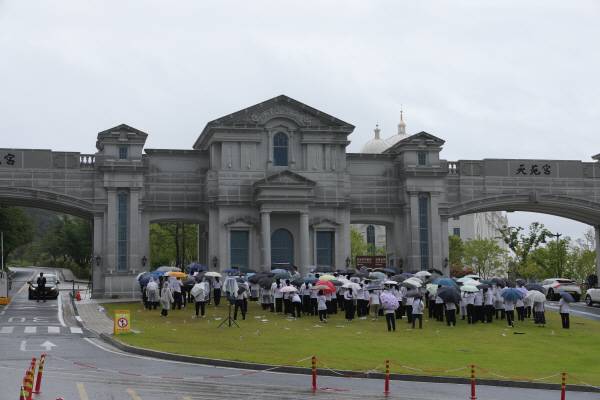 김건희 여사의 각종 의혹들을 수사하는 민중기 특별검사팀이 통일교 시설과 관계자를 대상으로 압수수색에 나선 18일 오전 경기도 가평군 통일교 본부에서 신도들이 집회를 열고 있다. 연합뉴스