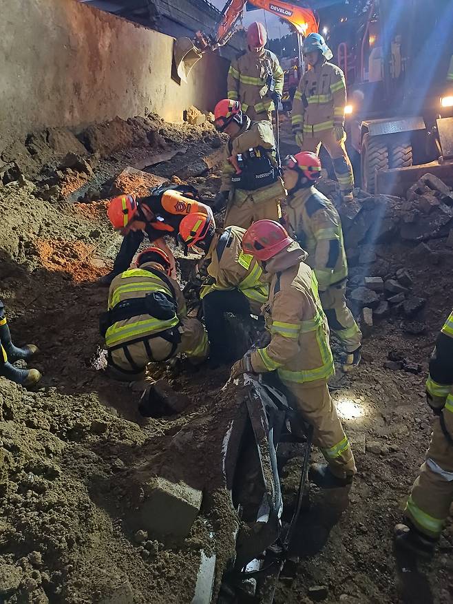 16일 오후 경기 오산시 가장교차로 고가도로의 10m 높이 옹벽이 도로로 무너지며 차량 2대를 덮치는 사고가 발생해 소방대원들이 구조작업을 하고 있다. 경기도소방재난본부 제공