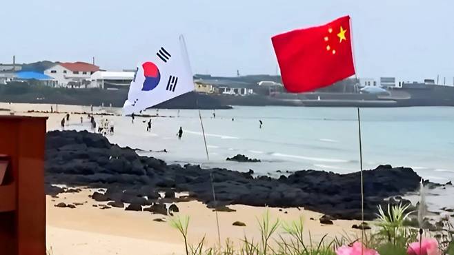 제주 우도 해변에 게양된 중국 국기(오성홍기). 이 사진이 온라인 커뮤니티에서 확산하면서 "제주도가 중국 섬이 됐다"는 괴담이 잇따랐다. / 사진 = 온라인 커뮤니티 갈무리