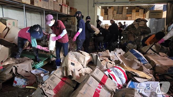 20일 아산 염치읍 일회용품 유통업체에서 공무원 등이 침수 피해복구작업을 돕. 2025.7.20/뉴스1ⓒNews1 이시우 기자