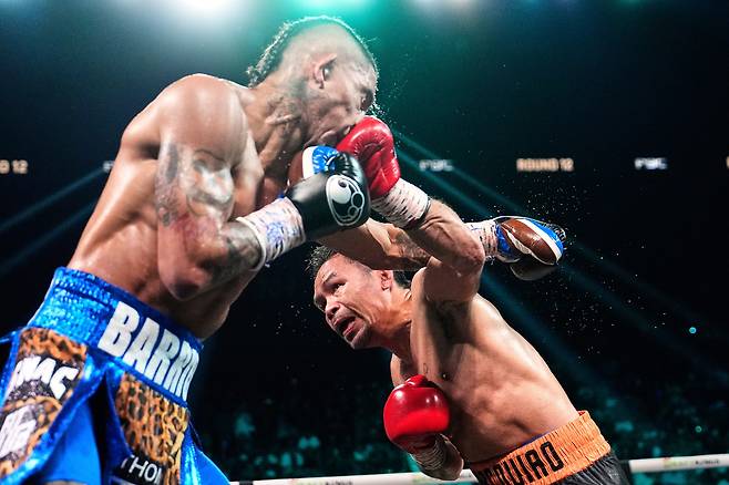 매니 파키아오(오른쪽)가 20일(한국 시각) 4년 만의 실전 복귀전에서 현 웰터급 챔피언 마리오 바리오스에게 주먹을 날리고 있다. /AP 연합뉴스