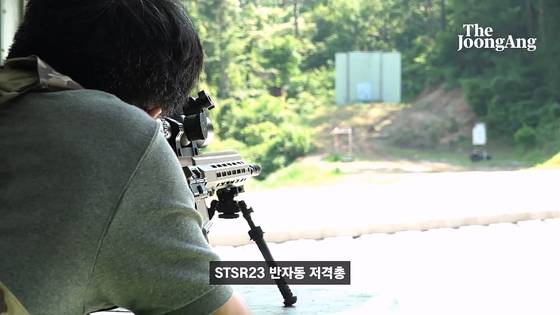 기자가 STSR23 반자동 저격총을 쏘고 있다. 화면 캡처