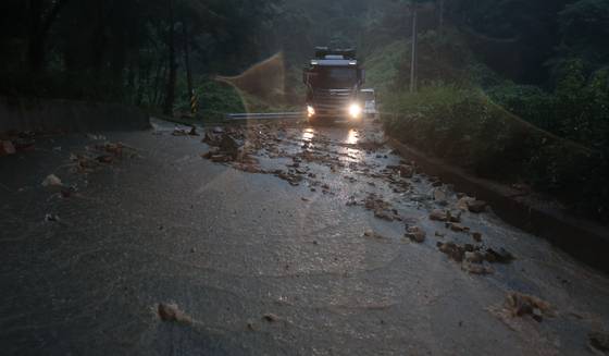 폭우로 인해 19일 오후 경남 산청군 단성면 한 도로에 산사태가 발생, 돌과 나무 등이 깔려 있다. 연합뉴스