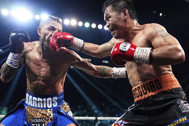 매니 파키아오(오른쪽)가 20일 미국 라스베이거스 MGM 그랜드 가든 아레나에서 열린 WBC 웰터급 세계챔피언전에서 마리오 바리오스의 안면에 라이트 스트레이트를 적중시키고 있다. 파키아오는 이날 자신보다 열여섯 살 어린 챔피언 바리오스를 상대로 녹슬지 않은 경기력을 선보이며 무승부를 기록했다. AP연합뉴스