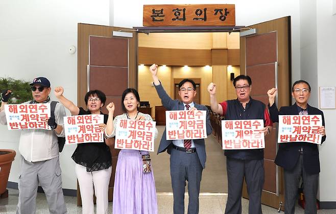 장혁(오른쪽 세번째)의원과 시민단체·장 의원 지역구 주민들이 18일 천안시의회 본회의장 앞에서 여행사에 떼인 해외연수비용과 계약금 등을 반납하라는 시위을 벌였다.