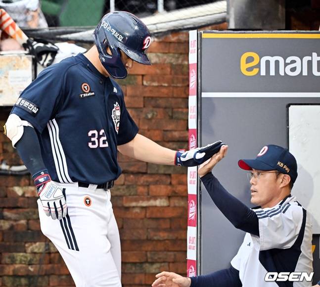 김재환(왼쪽)이 조성환 감독 대행과 하이파이브를 하고 있다.