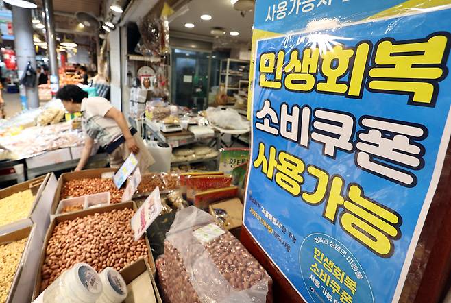 민생회복 소비 쿠폰 1차 신청 첫날인 21일 서울의 한 전통시장에 쿠폰 사용이 가능하다는 내용의 포스터가 붙어 있다. /뉴스1