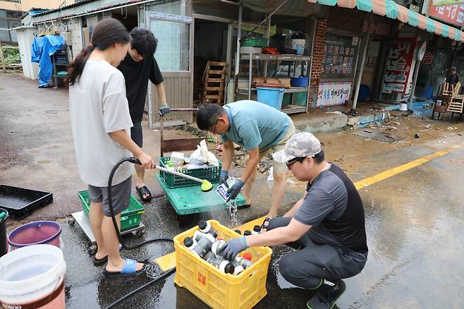 충남 당진 전통시장에서 농약·종묘사를 운영하는 김춘재씨 가족이 물에 잠겼던 씨앗봉투와 과수 영양제가 든 병을 씻어 말리는 복구작업을 하고 있다. 당진=김정모 기자