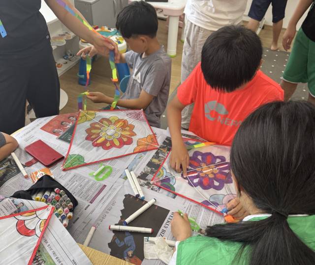 통영시새마을회는 지난 20일 다움청년새마을연대와 함께 통영육아원을 찾아 아이들과 전통놀이 시간을 가졌다. 연대 회원들이 아이들과 연을 만들고 있다. 사무국 제공