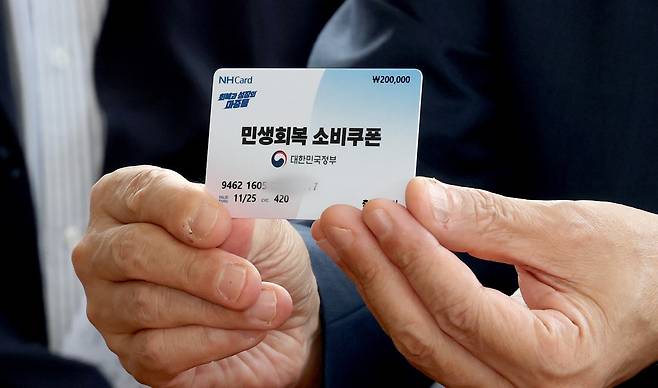 구윤철 경제부총리 겸 기획재정부 장관이 21일 오후 민생회복 소비쿠폰 시행 첫날 충남 공주시 산성시장을 방문 과일가게 등 재래시장 소비쿠폰 사용을 점검하며 소비쿠폰으로 과일을 구매하러 나온 시민의 카드를 들어 보이고 있다./뉴스1