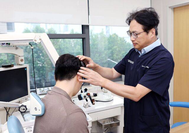 최재영 세브란스병원 이비인후과 교수가 인공와우 장비 중 바깥에 착용하는 어음처리기를 살펴보고 있다. 어음처리기는 외부 소리를 디지털 신호로 바꿔 체내 임플란트로 보내는 역할을 한다.