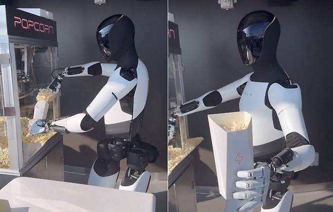 테슬라가 개발 중인 휴머노이드 로봇 ‘옵티머스’가 손님에게 팝콘을 건네고 있다. /엑스(X·옛 트위터)