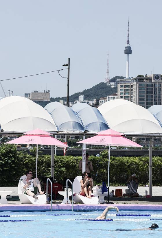 잠원 수영장 너머로 남산 서울타워가 보인다. 핑크빛 파라솔은 지드래곤이 설립한 저스피스 재단의 조언을 받아 색을 선정했다. 김경록 기자