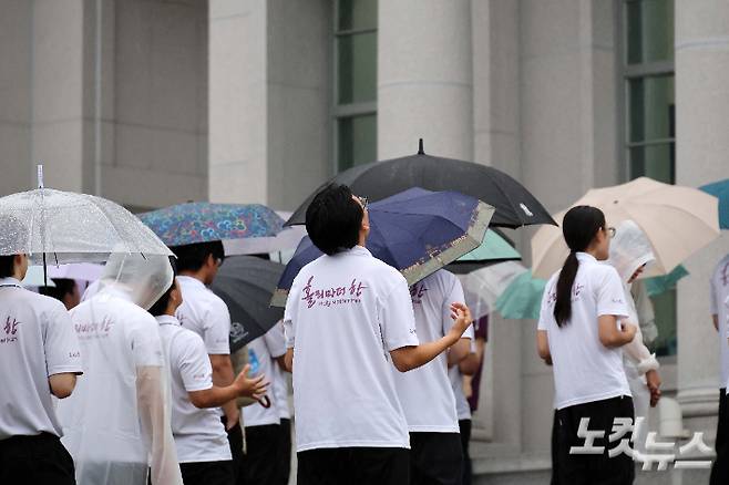 18일 오전 김건희 여사 관련 의혹을 수사하는 민중기 특별검사팀이 이른바 '건진법사 게이트'와 관련해 통일교 압수수색에 착수했다. 건진법사 게이트는 무속인 건진법사 전성배 씨가 2022년 교단 현안 관련 청탁을 받고 통일교 측으로부터 김건희 여사 선물용으로 받은 샤넬 백과 고가의 목걸이 등을 김 여사에게 전달했다는 의혹이다. 검찰이 압수수색에 나선 통일교 천정궁은 한학자 총재의 거주지로도 알려져 있다. 사진은 이날 가평 천정궁 앞에 모인 신도들의 모습. 가평=박종민 기자
