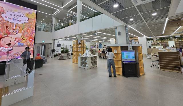 도서관에 처음 들어서면 보이는 실내 모습. 좌측의 7m 높이 초대형 미디어월에 만화적 감성을 담은 콘텐츠와 도서관 안내 정보가 재생된다.