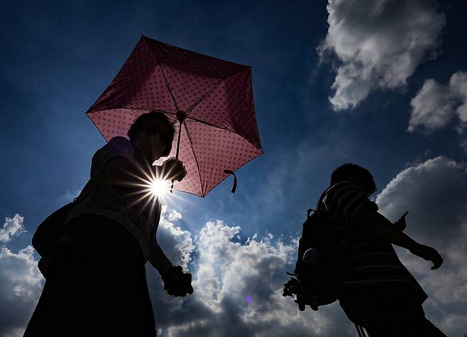폭염 경보가 이어진 23일 동대구역 광장에서 한 시민이 양산을 쓰고 이동하고 있다. 연합뉴스