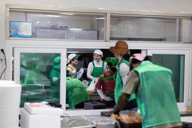 김혜경(뒷줄 가운데) 여사가 24일 집중 호우 피해를 입은 경기 가평군을 찾아 복구 지원 활동에 나선 군 장병들에게 제공할 식사를 준비하고 있다. 대통령실 제공