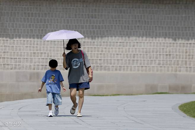 “덥다 더워” 전국 대부분 지역에서 한낮 최고기온이 34도를 웃도는 찜통더위가 이어진 24일 양산을 쓴 시민이 서울 종로구 경복궁 앞을 걸어가고 있다. 문재원 기자 mjw@kyunghyang.com