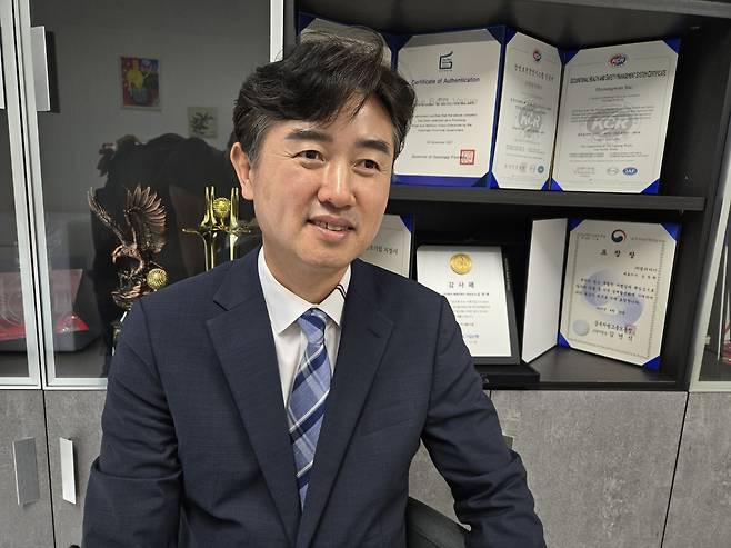 파주에 위치한 형원이엔지 사무실 앞에서 포즈를 취한 김정환 대표. 뒤에 진열돼 있는 각종 특허증과 감사패, 표창장에서 그동안의 업력과 기업의 사회적책임 실천 노력이 엿보인다.