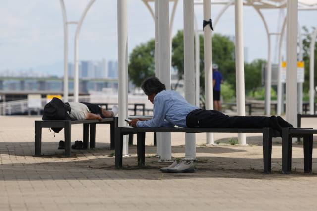 시민들이 그늘 아래서 폭염을 피하는 모습 사진 = 연합뉴스