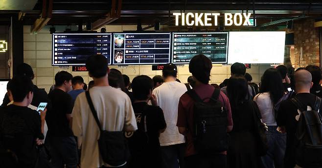 정부가 영화 관람료 6000원을 할인해주는 쿠폰 450만장을 25일 오전 10시부터 선착순 배포한다. 사진은 24일 서울 시내 한 영화관을 찾은 시민들이 한정판 굿즈를 받기 위해 매표소에서 줄 서서 기다리고 있다. (사진=뉴스1).