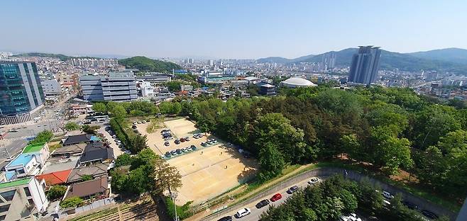 청주시민들이 임시 테니스장·산책 공간 등으로 이용하는 옛 청주 국정원 터. 청주시는 옛 국정원 정문 앞 주택가(사진 왼쪽) 등 6천㎡를 포함해 민관 도시개발사업 추진을 검토한다. 오윤주 기자