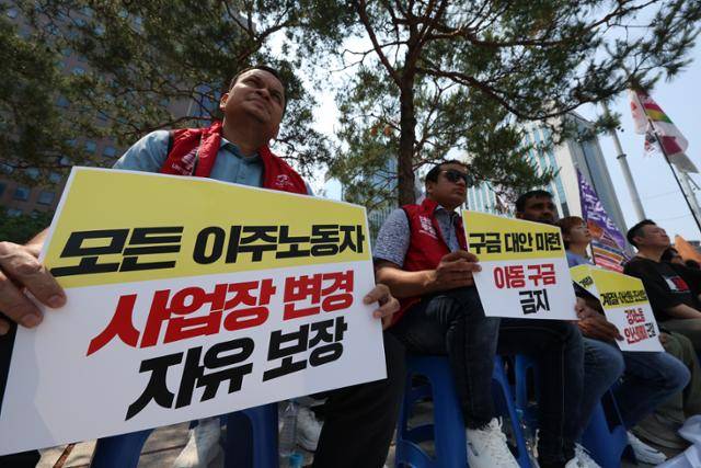 지난달 1일 서울 종로구 보신각에서 '차별을 넘어 평등사회를 향해 이주민과 함께하는 시민행진' 사전집회가 열리는 가운데, 한 집회 참가자가 '모든 이주노동자 사업장 변경 자유 보장' 손팻말을 들고 있다. 뉴시스