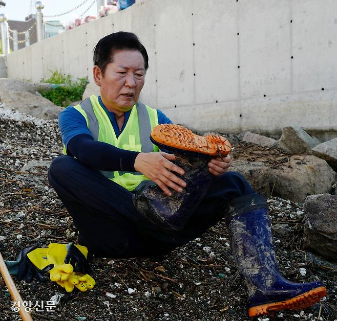 더불어민주당 대표 선거에 출마한 정청래 의원이 지난 26일 전남 목포시 해안로에서 수해 복구 작업을 펼치다 휴식하며 장화를 벗고 있다. 목포|허진무 기자