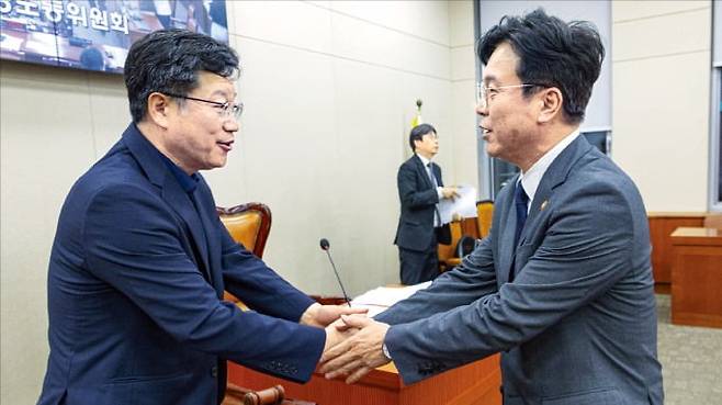 < 노란봉투법 통과되자 악수 > 더불어민주당 소속 안호영 국회 환경노동위원장(왼쪽)과 김영훈 고용노동부 장관이 28일 환노위 전체회의에서 ‘노란봉투법’이 통과된 뒤 악수하고 있다. 연합뉴스