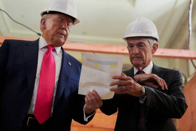 제롬 파월 연방준비제도(Fed·연준) 의장이 지난 24일(현지 시간) 미국 워싱턴DC 연준 청사 리모델링 현장을 방문한 도널드 트럼프 대통령에게 건축 비용이 초과됐다는 내용의 서류를 전달받고 있다. 로이터연합뉴스