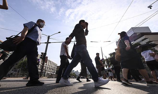 서울 서초구 고속버스터미널 인근에서 시민들이 강하게 내리쬐는 햇볕을 피해 출근길에 나서고 있다. 뉴시스
