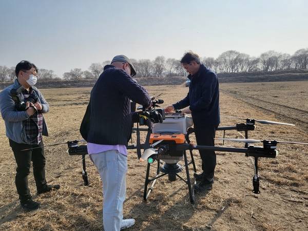 장항습지에서 드론을 활용해 철새 먹이주기를 하고 있는 봉사단원들. /고양시 제공