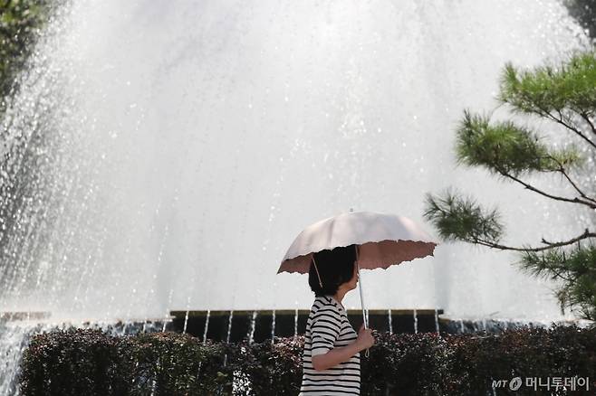 (대구=뉴스1) 공정식 기자 = 폭염이 계속된 1일 대구 중구 대구시청 동인청사 앞에서 한 시민이 양산을 펼쳐 뙤약볕을 가린 채 분수대를 지나고 있다. 2025.8.1/뉴스1 Copyright (C) 뉴스1. All rights reserved. 무단 전재 및 재배포, AI학습 이용 금지. /사진=(대구=뉴스1) 공정식 기자