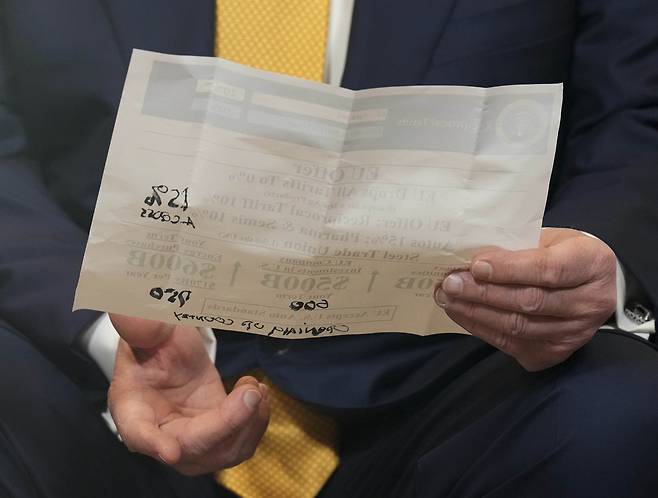 27일(현지시간) 스코틀랜드 턴베리에서 미·유럽연합(EU) 무역합의를 발표하는 도널드 트럼프 미국 대통령이 손으로 숫자를 수정한 문서를 들고 있다. AP연합뉴스