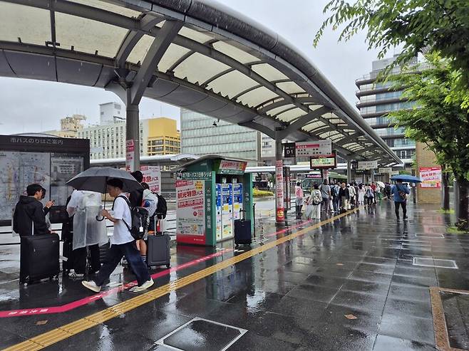 교토역 버스정류장에 관광객들이 줄을 서 있다.