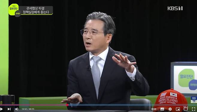 김용범 대통령실 정책실장이 3일 한국방송 일요진단 라이브에 출연해 미국과의 관세 협상 과정에 대해 설명하고 있다. 김 실장 옆에 한미 조선 협력 프로젝트를 상징하는 ‘마스가’(Make America Shipbuilding Great Again) 모자가 놓여있다. 한국방송 유튜브 갈무리