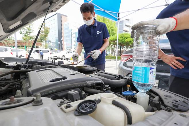 사진은 서울시 자동차전문정비사업조합(카포스) 송파구지회 정비사들이 13일 서울 송파구민회관 주차장에서 여름 휴가철을 맞아 차량 무상점검을 실시하고 있는 모습./사진=뉴스1 민경석 기자