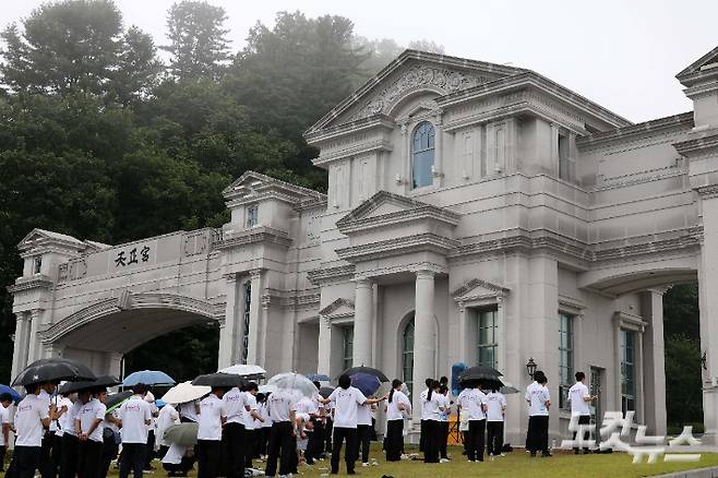 지난달 18일 오전 김건희 여사 관련 의혹을 수사하는 민중기 특별검사팀이 이른바 '건진법사 게이트'와 관련해 통일교 압수수색에 착수했다. 건진법사 게이트는 무속인 건진법사 전성배 씨가 2022년 교단 현안 관련 청탁을 받고 통일교 측으로부터 김건희 여사 선물용으로 받은 샤넬 백과 고가의 목걸이 등을 김 여사에게 전달했다는 의혹이다. 검찰이 압수수색에 나선 통일교 천정궁은 한학자 총재의 거주지로도 알려져 있다. 사진은 이날 가평 천정궁 앞에 모인 신도들의 모습. 가평=박종민 기자
