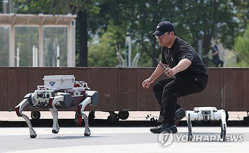 폴리봇과 대치하는 용의자 (대구=연합뉴스) 김현태 기자 = 28일 오후 대구 수성구 수성못에서 열린 대구경찰청의 AI드론·로봇을 이용한 디지털 합동 순찰 시연에서 폴리봇(순찰로봇) 2대가 성추행용의자와 대치하고 있다. 2025.5.28 mtkht@yna.co.kr