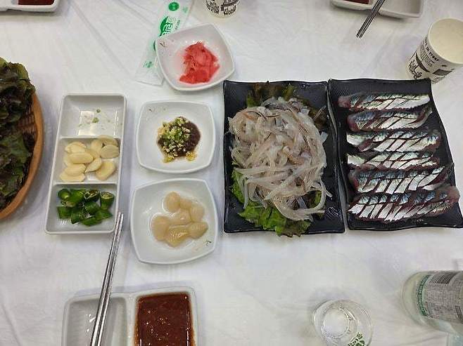 속초 오징어 난전 인근 횟집에서 구매한 2만원짜리 오징어 두 마리와 서비스 회 (출처=속초시청 자유게시판)