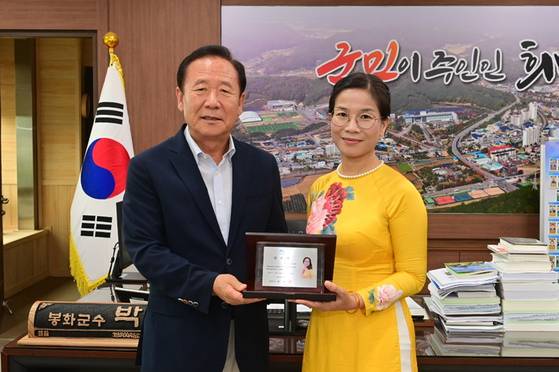 지난 6일 경북 봉화군청에서 열린 봉화군 홍보대사 위촉식에서 박현국 봉화군수가 베트남 출신 도 옥 루이엔 교수(오른쪽)에게 위촉패를 전달한 뒤 기념촬영을 하고 있다. 사진 봉화군